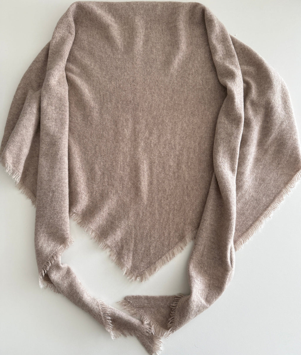 Folded beige bandanna on a white surface